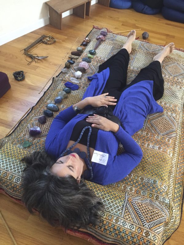 Nina taking in the vibes of the Crystal mini session padded mat, with attendant private session stones